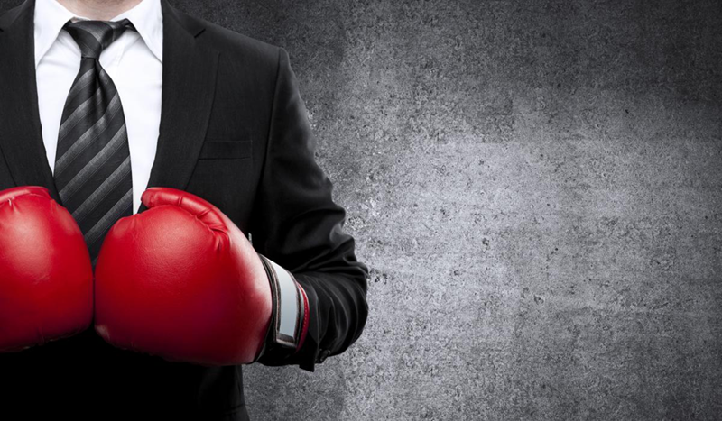 Picture of man in suit wearing boxing gloves